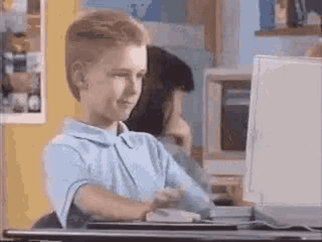Kid giving thumbs up at computer.